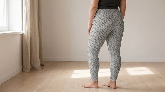Three-quarter rear view of a curvy woman standing barefoot in FIERCEPULSE Anti Cellulite Pattern Leggings, a grey lattice print