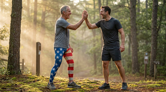 Father in his 60s wearing vintage American Flag FIERCEPULSE meggings high-fives his adult son after a sunrise trail run