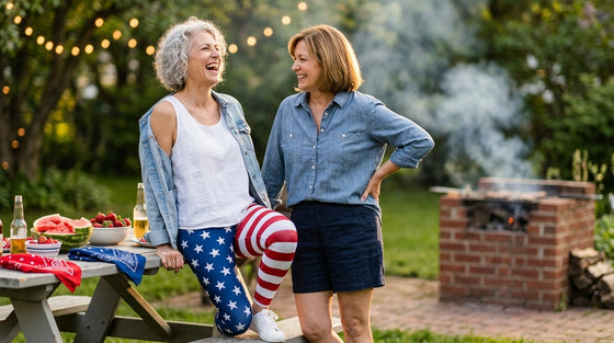 Two women in their late 50s and 60s laughing at a Memorial Day backyard cookout, one wearing American Flag stars-and-stripes leggings - FIERCEPULSE patriotic leggings styling guide