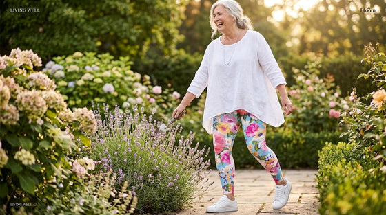 Confident plus-size woman in floral-print FIERCEPULSE leggings and a white tunic walking in a summer garden